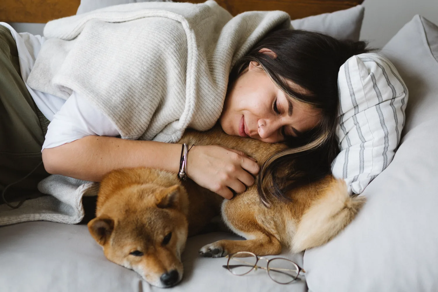 A woman resting cheek-to-cheek with her dog